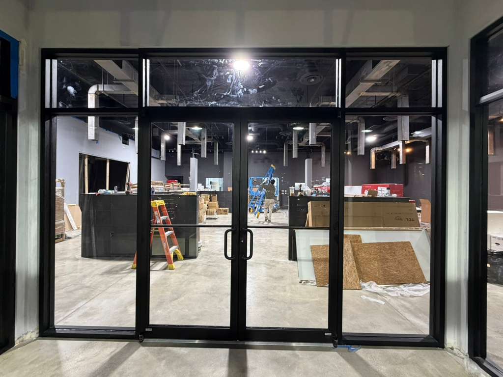 Storefront double glass door with black aluminum frame and transom, interior view