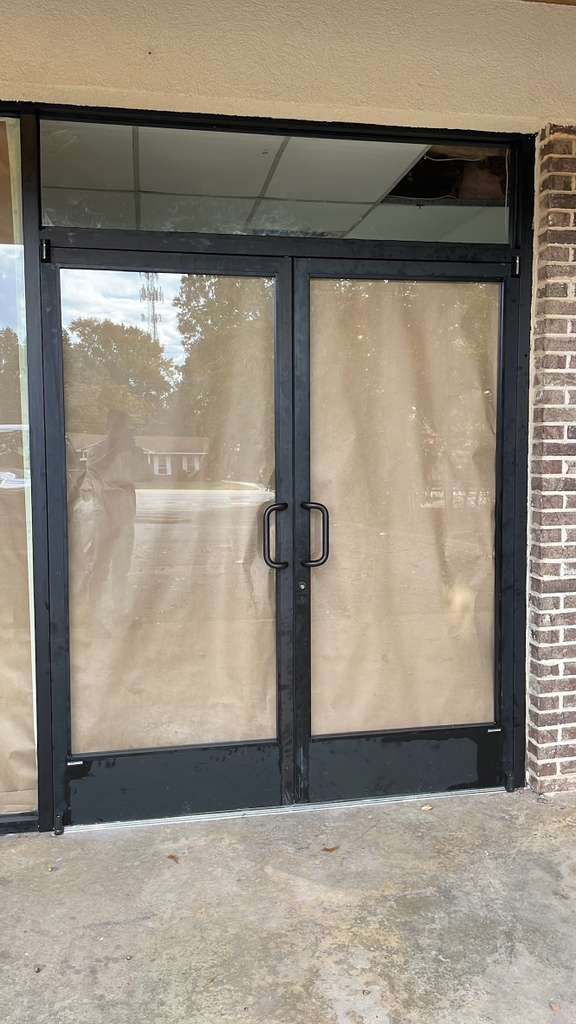 Storefront glass door installed in a brick commercial building